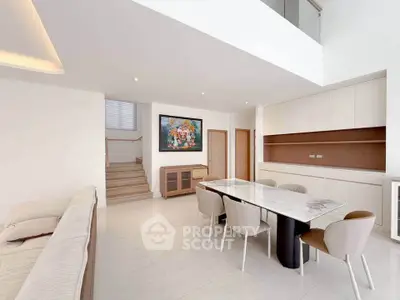 Spacious modern dining area with elegant marble table and cozy seating in a bright open-plan layout.