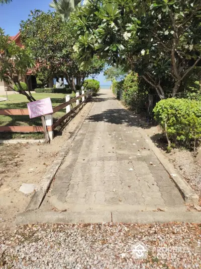 Charming garden pathway leading to a serene beachfront view