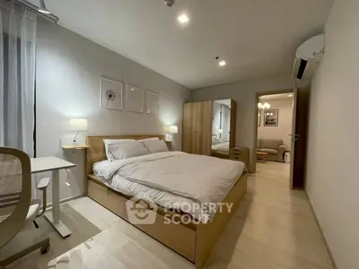 Modern bedroom with cozy decor and stylish furniture in a well-lit apartment.