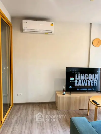 Modern living room with air conditioning and TV, featuring stylish wooden flooring and minimalist decor.