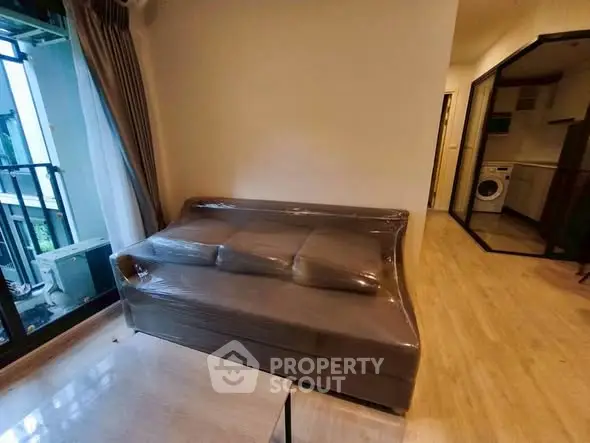 Modern apartment interior with cozy living room and kitchen featuring a washing machine, ideal for urban living.