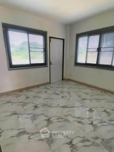Bright room with marble flooring and large windows offering scenic views, perfect for a serene living space.