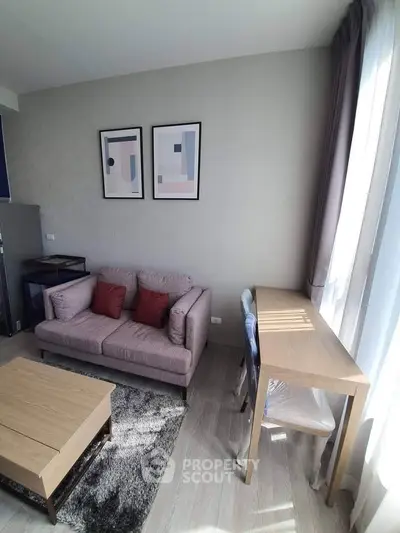 Modern living room with stylish decor, featuring a cozy sofa, wooden coffee table, and natural light from large windows.