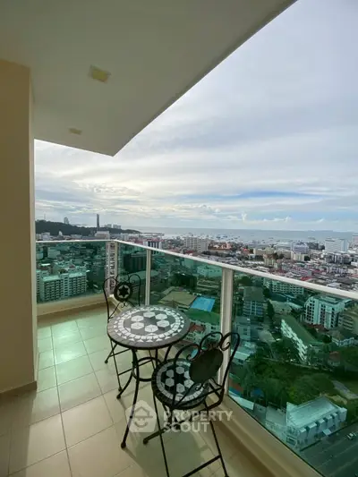 Stunning high-rise balcony with panoramic city and ocean views, perfect for relaxation.