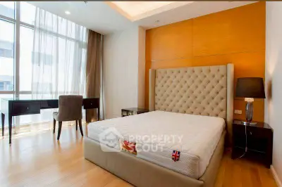 Luxurious bedroom with elegant decor and large window offering natural light.