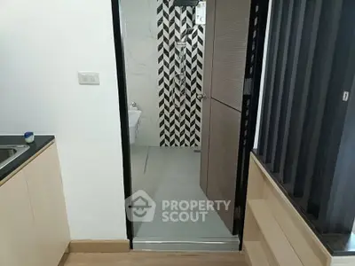 Modern interior with a sleek kitchen and stylish bathroom entrance