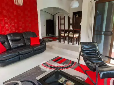 Stylish living room with modern furniture and vibrant red accents, perfect for relaxation and entertaining.