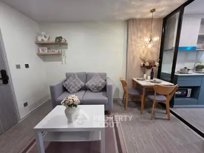 Modern living room with cozy sofa, dining area, and stylish decor in a compact apartment.