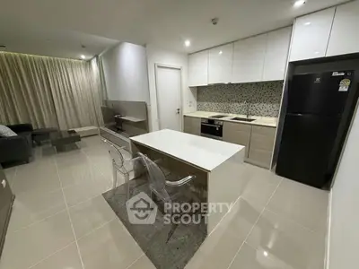 Modern open-layout kitchen and living room with sleek design and contemporary furnishings.