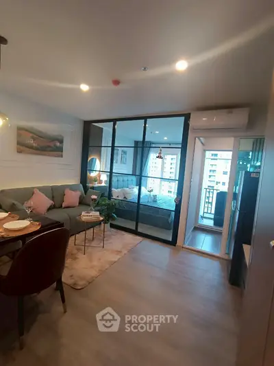 Modern open-plan living room with cozy seating and balcony view