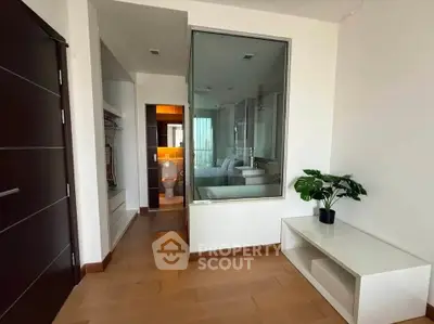 Modern apartment interior with wooden flooring and glass partition, featuring a cozy bedroom and stylish decor.