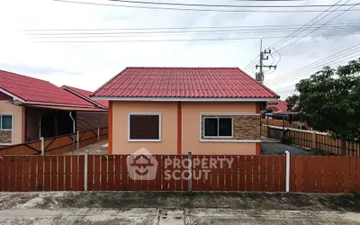 Charming single-story house with red roof and fenced yard in a serene neighborhood.