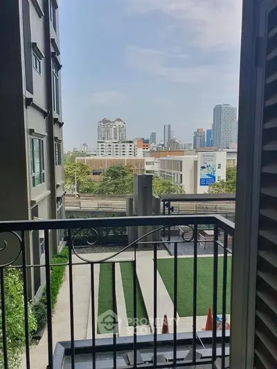 Urban apartment balcony with city skyline view and modern architecture.