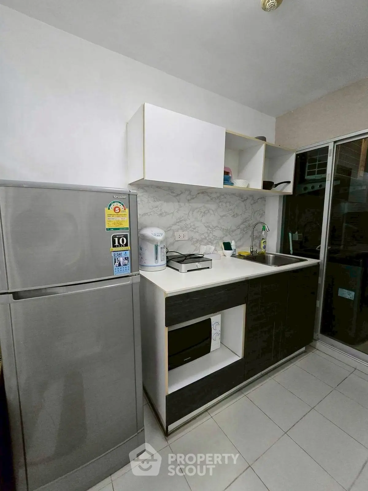 Modern kitchen with sleek cabinetry and stainless steel appliances in a contemporary apartment.