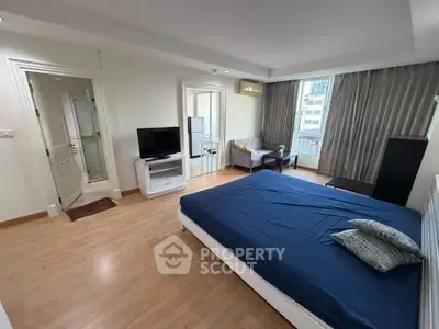 Spacious studio apartment with modern furnishings and large windows