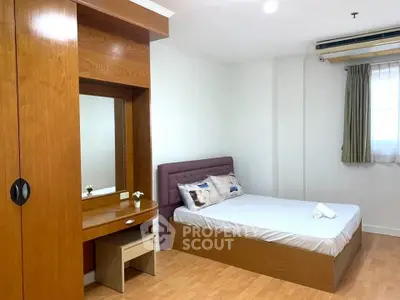 Spacious bedroom with wooden furniture and natural light