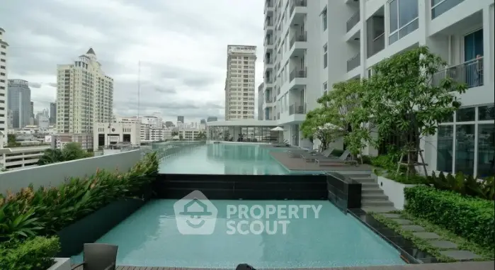 Luxurious rooftop pool with stunning city views in modern high-rise building.