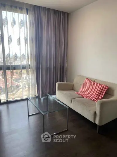 Chic modern living room with floor-to-ceiling windows and stylish decor in urban apartment.