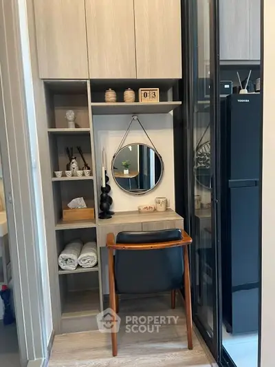 Cozy study nook with modern shelving and stylish chair in compact apartment.