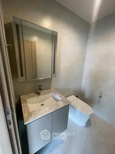 Modern bathroom with sleek vanity and contemporary toilet design.