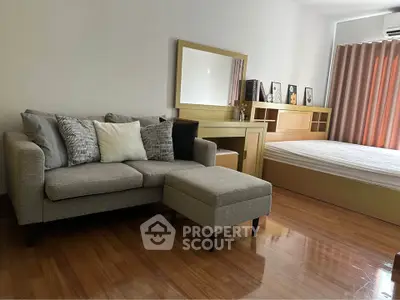 Cozy bedroom with stylish sofa and wooden furniture, perfect for modern living.