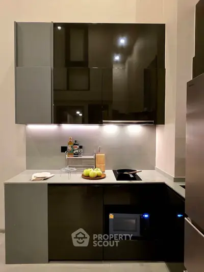Modern kitchen with sleek cabinetry and built-in appliances, featuring a stylish countertop and ambient lighting.