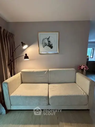 Cozy living room with beige sofa, stylish lamp, and horse artwork, perfect for relaxation and modern living.