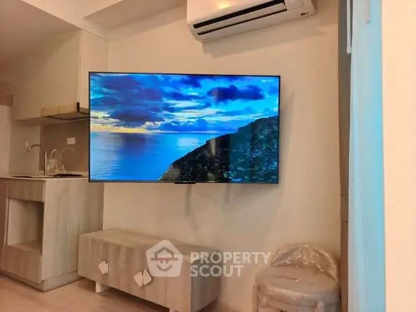 Modern living room with wall-mounted TV and air conditioning in stylish apartment.