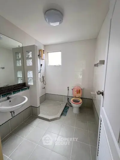 Spacious bathroom with modern fixtures and a unique shower design.