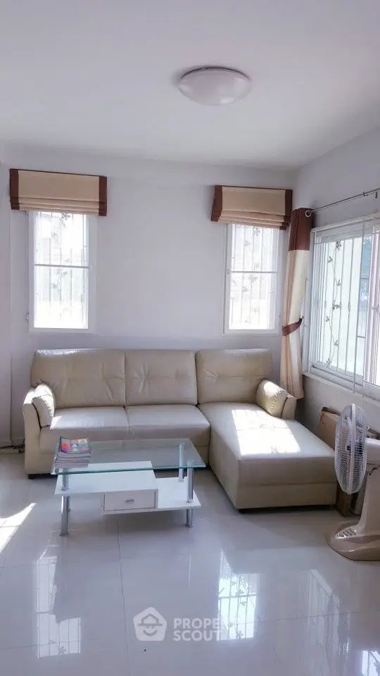 Bright living room with modern white leather sofa and glass coffee table