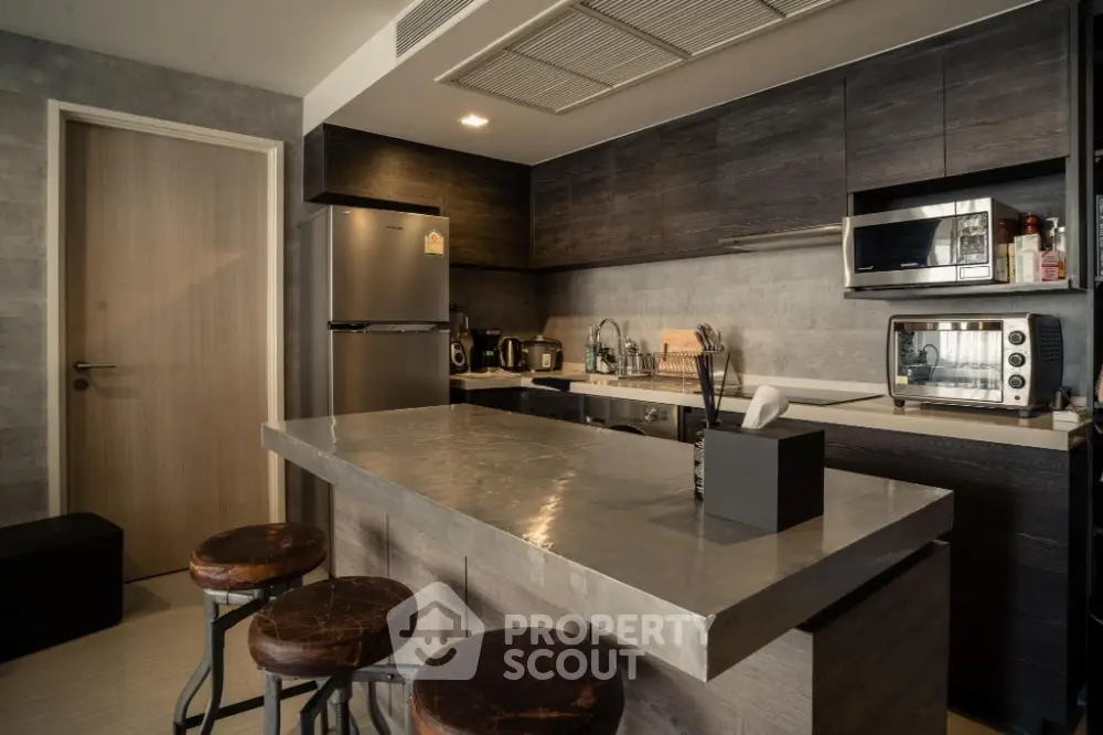 Modern kitchen with sleek dark cabinets and stainless steel appliances