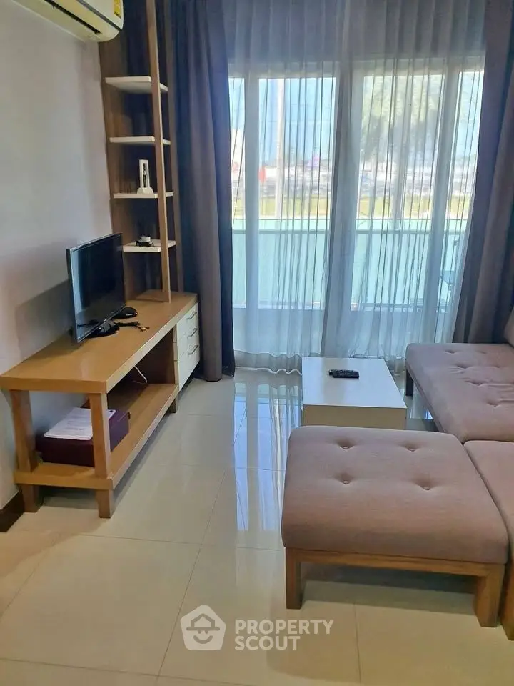 Modern living room with stylish furniture and large window offering natural light.