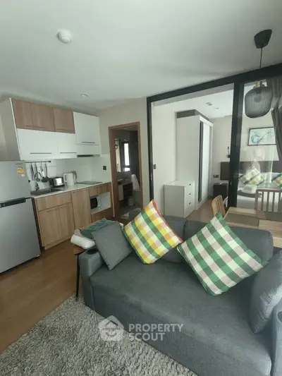 Modern open-plan living room with kitchen, featuring stylish decor and cozy ambiance.