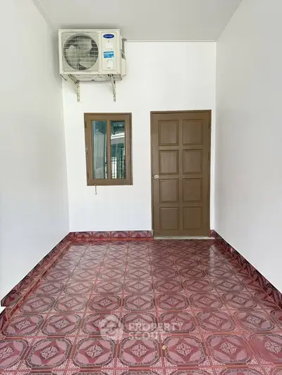 Spacious room with patterned tile flooring and air conditioning, ideal for versatile use.