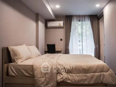 Cozy bedroom with modern decor and natural light from large window.