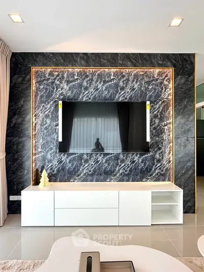 Modern living room with stylish marble accent wall and sleek TV setup