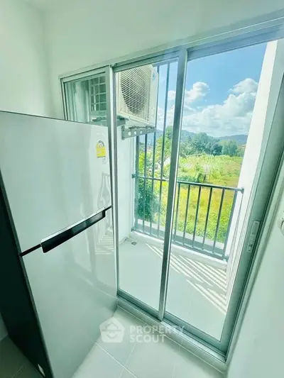 Bright balcony with scenic view and modern fridge, perfect for enjoying fresh air and nature.