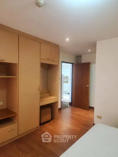 Spacious bedroom with built-in wooden wardrobe and cozy lighting