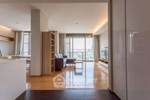 Spacious modern living room with city view and elegant wooden flooring.