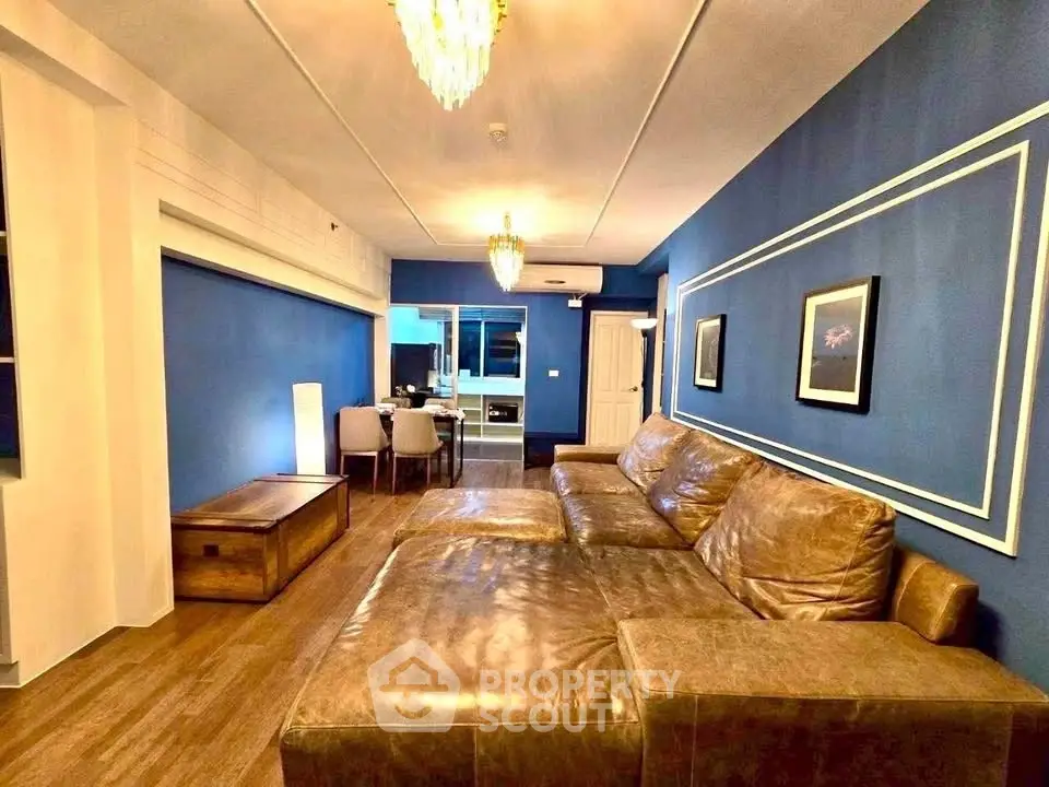 Spacious living room with elegant blue walls and luxurious leather sofa