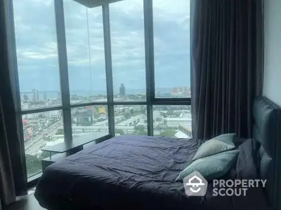 Luxurious bedroom with panoramic city view from floor-to-ceiling windows