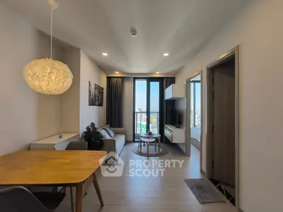 Modern living room with dining area and city view balcony in stylish apartment.