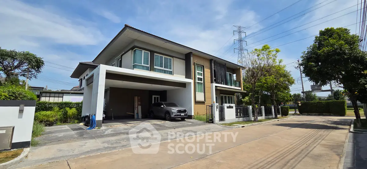 Modern two-story house with spacious driveway and carport in a serene neighborhood.