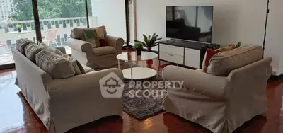Spacious living room with cozy sofas and large TV, featuring a balcony view.