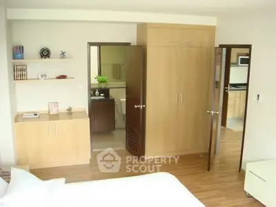 Spacious bedroom with wooden flooring and built-in wardrobe, offering a cozy and functional living space.