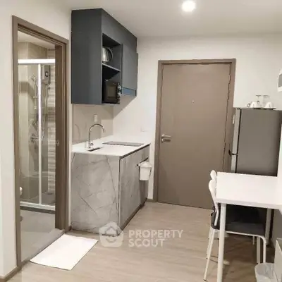 Modern compact kitchen with sleek design and integrated appliances in a cozy apartment.