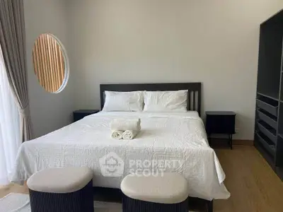 Spacious bedroom with modern decor and natural light, featuring a large bed and stylish furnishings.