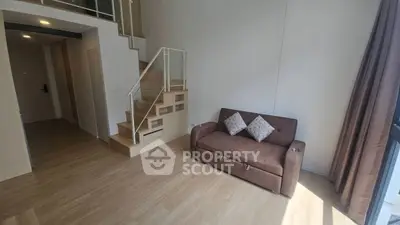 Modern living room with loft-style staircase and cozy brown sofa