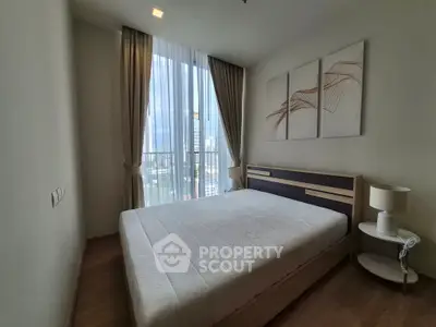 Modern bedroom with large window and city view, featuring stylish decor and natural light.