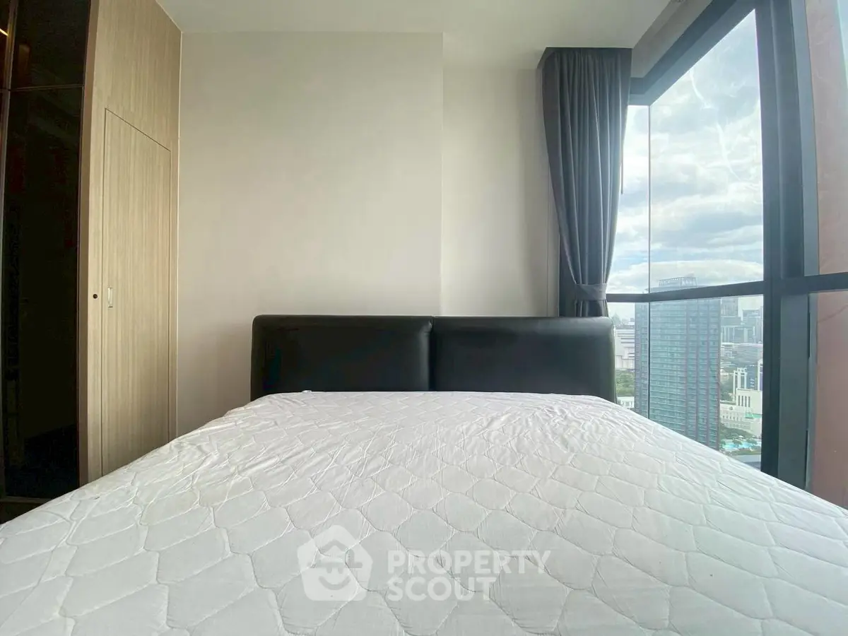 Modern bedroom with large window offering stunning city view